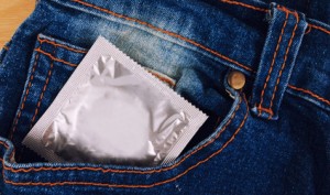 Condom in the vintage blue jeans pocket. Focus on the condom.